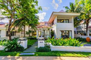 ダナンにあるOcean Villa Pool Retreat In Da Nangのヤシの木が目の前に広がる家