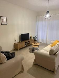 a living room with a couch and a tv at Thalassa Grammeno seaview house in Palaiochora
