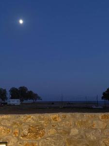 a moon over a beach with the ocean in the background at Thalassa Grammeno seaview house in Palaiochora