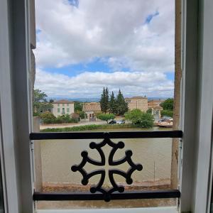 a window with a view of a city at La Maison du Canal- vue Canal- L'ère du Temps in Homps +13 photos