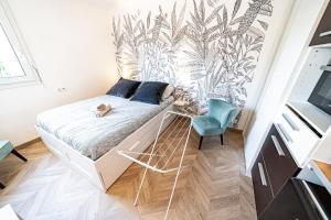a small bedroom with a bed and a blue chair at Le petit Million- joli studio rénové-Flachet in Villeurbanne