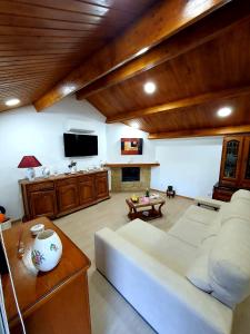 uma sala de estar com um sofá branco e uma televisão em A CASINHA DO CARREIRAS em Barroselas