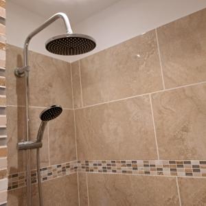 a shower with a shower head in a bathroom at La Maison du Canal- vue Canal- L'ère du Temps in Homps
