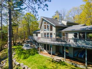 una casa rodeada de porche y terraza en Getaway Cottage LAKE FRONT Muskoka Room Kayaks, en Dwight