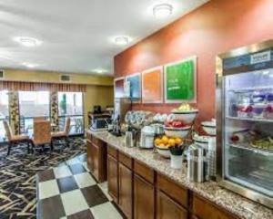 a restaurant with a counter with fruits and food at Quality Inn & Suites in Mount Pleasant