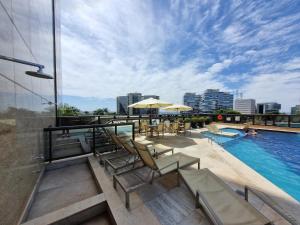 a swimming pool with lounge chairs and a building at Cullinan apart-hotel particular in Brasilia