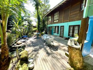 une terrasse en bois devant une maison dans l'établissement Casa Selva - Vila do Abraão - Ilha grande, à Abraão