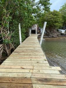 un puente de madera sobre un cuerpo de agua en Sunrise Cottage, en Fajardo