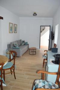 Una sala de estar con un sofá, una mesa y sillas. en Nuestra casa en Vejer, en Vejer de la Frontera