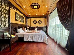 a bedroom with a bed with a bird on it at Cozy Boutique Cruise in Cat Ba