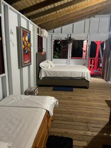 a bedroom with two beds and a wooden floor at Sunrise Cottage in Fajardo