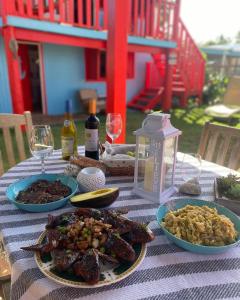 a table topped with plates of food and wine glasses at Sunrise Cottage in Fajardo