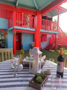a table with a bottle of wine and wine glasses at Sunrise Cottage in Fajardo