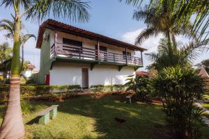 une maison avec un balcon et une cour avec des palmiers dans l'établissement Hotel Fazenda Vale Amanhecer, à Igarapé