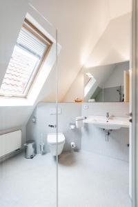 uma casa de banho com um WC, um lavatório e uma janela em Hotel Stadt Kassel em Rinteln