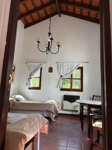 Habitación con 2 camas y lámpara de araña. en Hotel Torrontes en San Lorenzo