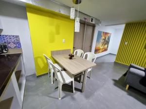 a dining room with a wooden table and white chairs at Tranquilo Apartamento Central Cerca a la Playa Puerto Colombia in Puerto Colombia