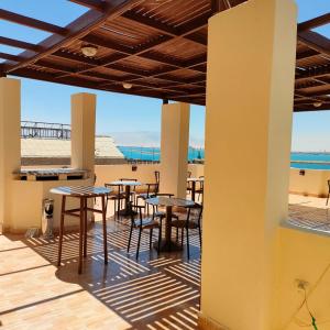 un patio con mesas y sillas en la playa en نادى البحارة الدولى بالسويس, en Suez