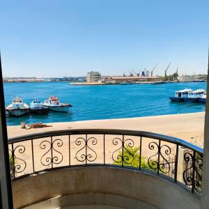 uma varanda com vista para um corpo de água com barcos em نادى البحارة الدولى بالسويس em Suez