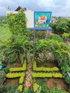 un giardino di fronte a un edificio con un cartello di Mango Tree Homestay a Hampi
