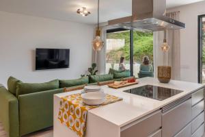 a kitchen with a green couch and a table at Funchal with pool - Uptown 13 apartment in Funchal