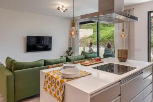 a kitchen with a green couch and a table at Uptown 13 apartment by An Island Apart in Funchal