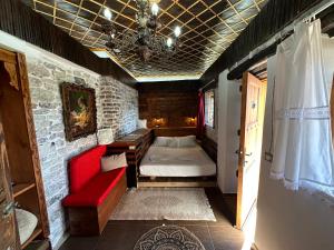 ein Schlafzimmer mit einem Bett und einem roten Sofa in der Unterkunft Guesthouse Mele in Gjirokastër