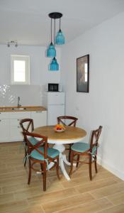 a kitchen with a wooden table and chairs and a kitchen with a sink at Nuestra casa en Vejer in Vejer de la Frontera
