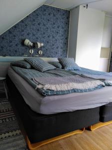 - une chambre avec un grand lit et un mur bleu dans l'établissement Lägenhet naturnära i Henån, à Henån