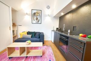 a kitchen and living room with a couch and a table at Le petit Lafayette-Halles Paul Bocuse- Part Dieu in Lyon