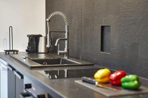 a kitchen counter with a sink and fruits on a cutting board at Le petit Lafayette-Halles Paul Bocuse- Part Dieu in Lyon