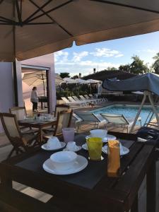 una mesa con platos junto a una piscina en Sentirsi a casa, en Portacomaro