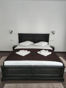 a bed with two pillows on top of it at Pensiunea Tincu in Satu Şugatag