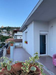 Cette maison blanche dispose d'un balcon avec un canapé rose. dans l'établissement SI-RI Apartment, à Gjirokastër