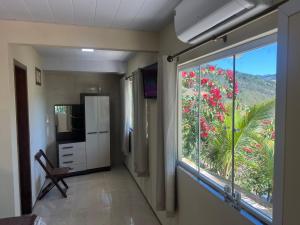 een kamer met een raam en een keuken met uitzicht bij Casa nas montanhas com piscina e vista panorâmica in Domingos Martins
