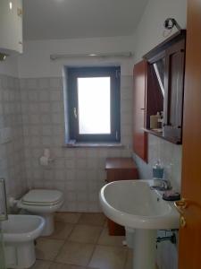 Canino的住宿－Appartamento Indipendente，一间带水槽和卫生间的浴室以及窗户。
