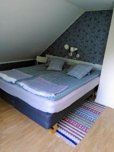 a bed with two pillows on it in a room at Lägenhet naturnära i Henån in Henån