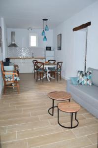 a living room with a couch and tables and a kitchen at Nuestra casa en Vejer in Vejer de la Frontera
