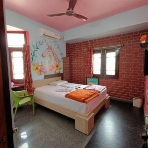 1 dormitorio con cama y pared de ladrillo en Mango Tree Homestay en Hampi