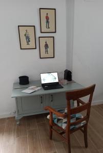 a desk with a laptop and a chair in a room at Nuestra casa en Vejer in Vejer de la Frontera