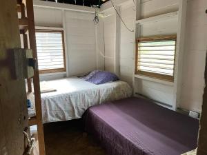 ein kleines Zimmer mit 2 Betten und einem Fenster in der Unterkunft Granja Integral Luz Del Corazon 