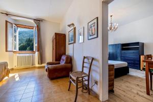 1 dormitorio con cama, silla y escritorio en Casa nel Borgo Iris, en Breguzzo