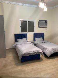 2 camas en una habitación con 2 ventanas en Al asalah apartments, en La Meca