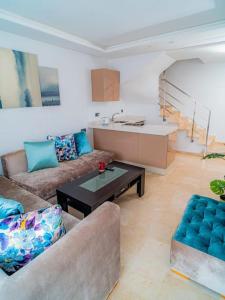 a living room with two couches and a table at Un charmant duplex à proximité de la corniche in Casablanca