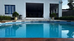 una gran piscina azul frente a una casa en Casa bella de campo Wifi billar piscina bolirana !privado!, en Carmen de Apicalá