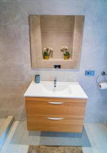 a bathroom with a sink and a window with flowers at Un charmant duplex à proximité de la corniche in Casablanca