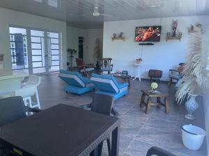 sala de estar con sillas azules y TV en la pared en Casa bella de campo Wifi billar piscina bolirana !privado!, en Carmen de Apicalá