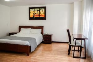 a bedroom with a bed and a table and a desk at Nogal Suite Hotel Pasto in Pasto +42 photos