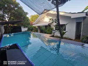 a swimming pool in front of a house at Bee Cottage Negombo in Negombo