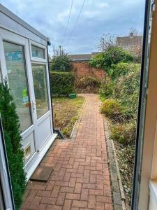 a brick walkway leading to a door of a house at Lovely 3 Bed with Free parking-Families, Professionals and Contractors Welcome in Luton